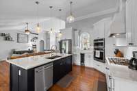 A beautiful and yet functional accent island is in the heart of the kitchen. A stainless steel dishwasher conveniently location next to the sink. Oh, do I spy with my eye a wine fridge beneath the serving window?!