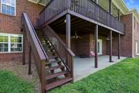 Another view of the covered patio from the walkout basement area and the stairs from the covered deck above that has just been refinished.