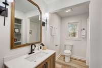 THIS IS THE NEW SECOND FULL BATH WITH A LINEN CLOSET, TILED SHOWER, GORGEOUS SCONCES, NEW VANITY, FIXTURES AND FLOORING.