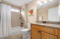 Upstairs hall Bathroom with tiled tub/shower combination and granite vanity.