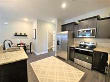 Another view of kitchen showing half bath in hallway (photo is of model home with same floor plan)
