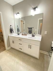 Master bathroom with double sinks, shower and walk-in closet (photo is from staged model home with same layout)