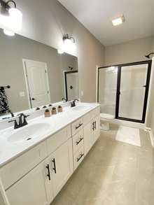 Master bathroom with double sinks, shower and walk-in closet (photo is from staged model home with same layout)