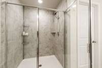 Large tile shower with glass door finishes off this great space.