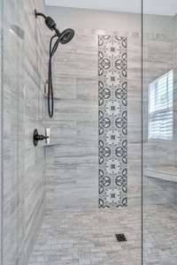 Indulge in the expansive, beautifully tiled shower, a stunning centerpiece of the Primary bedroom's ensuite oasis