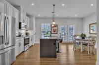 The Kitchen and Dining Area is spacious and has ample natural light as well as recessed lighting and pendant lights over the island.