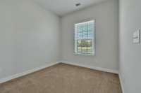 Bedroom 2 ~ neutral carpet and paint, single window with faux wood blinds, closet and wired for ceiling fan with light.