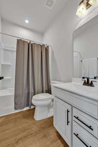 Hall Bathroom ~ LVP floor, upgraded raised panel vanity with cultured marble counter and sink, black hardware, black finish fixtures and vanity light.  There is a combo tub/shower with a recessed light and a linen closet.