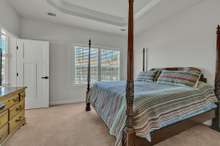 Owner's Bedroom ~ neutral carpet and paint, trey ceiling, recessed lights and double window with faux wood blinds.