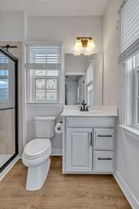 Owner's Bathroom ~ LVP floor, upgraded raised panel vanity with cultured marble counter and sink, black hardward, black finish fixture and vanity light.  There are 2 windows with faux wood blinds.