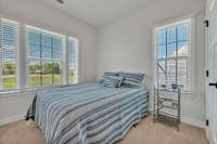 Bedroom 3 ~ neutral carpet and paint, large picture window plus single window with faux wood blinds, closet and wired for ceiling fan with light.