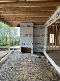 View of Covered Living Area with Wood burning fireplace *this home is under construction Built by Ford Classic Homes Photo taken 4/19/2