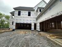 Spacious 4 Car Garge connects with extra storage area and pedestrian door.  *this home is under construction Built by Ford Classic Homes Photo taken 4/19/2