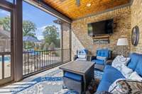 The dreamy screened porch overlooks the pool area and backyard.