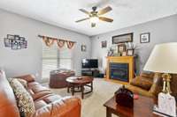 Living Room with decor paint colors off from kitchen and Dining Room; Well maintained carpet; electric fireplace