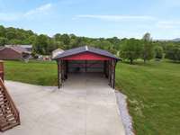 Large 26'x36'x14' RV garage with hookup on concrete circle driveway with well maintained deck and attached heated/cooled 2 car garage with encapsulated storm room 6'x42'