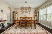 The formal dining room features updated lighting, hardwood floors, double window overlooking the front porch & yard areas, and a walk through to the kitchen & pantry area.