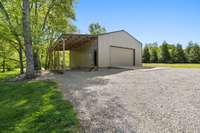 Pole-barn for all the toys with an over hang for your RV or camper with water source as well as 30 & 50 amp hook ups. 17x9 ft garage door on the front with 7x10 garage door located on the back of the shop. Bubble insulation with plywood just because.