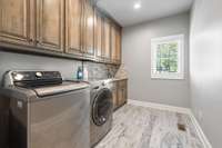 Laundry room with tons of storage and a sink that's located off the garage AND off one of the primary closets for hassle free washing.