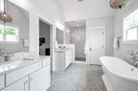 The primary bath has marble floors, double vanity, a freestanding tub and a large walk-in shower.