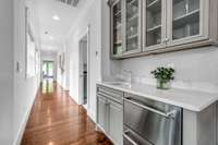 The recreation room has a wet bar in the corner with a 2-drawer refrigerator and a marble countertop.