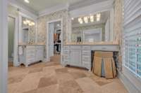 Primary en suite bath with double vanities, travertine floors and marble countertops