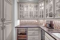 Butler's pantry with ample storage, sink, new ice maker and wine refrigerator.
