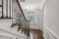 Light filled front entry with gleaming true hardwood floors