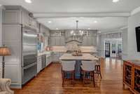 Open kitchen with large marble island and hardwood floors
