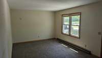 The spacious living room has new carpet and lots of natural light!