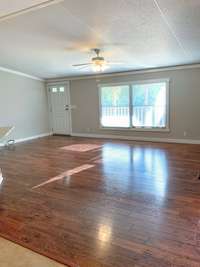 The large Living Room is just off the kitchen and dining area. Hardwood floors, lots of natural light, wood-paneled accent wall, and ceiling fan! What a great space for entertaining, the flow is AMAZING!