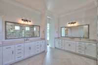 Dual vanities with expansive cabinetry.