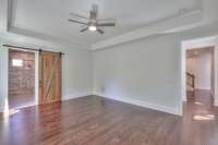 Owners Bedroom with tray ceiling and barn door.