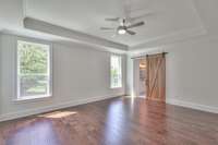 Owners Bedroom with tray ceiling and barn door.