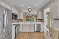 Recessed lighting reveals the details such as the beautiful tile backsplash.