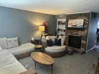 Another view of the great room featuring a wood burning fireplace .