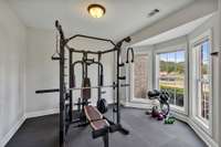 Gym equipment and floor mats do not stay.  Hardwood flooring that matches the entryway is underneath the mats.