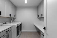 Laundry room with custom cabinetry and porcelain tile. LG Washer + Dryer.