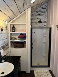 This bath was added to guest house which was built originally part of the house and moved to the side yard in 1906. The newly installed water heater is located behind the easily opened shelving.