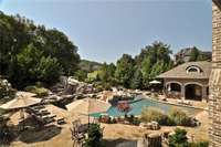 Magnificent outdoor oasis as seen from the master bedroom veranda! Swimming pools, waterfall, slide, heated screened porch, Full outdoor kitchen, pool bath, patio with fireplace and so much more!!!
