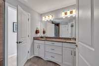 Double vanities with granite countertop. Open door is the water closet.