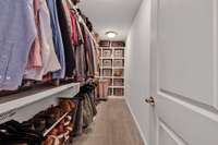 Deep walk-in closet with custom built shelving.