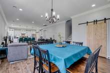 Dining room open to kitchen and living room, decorative barn doors to laundry