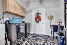 Downstairs laundry room with cabinets & utility sink