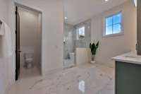 The second downstairs primary features another spacious bathroom with wet room.