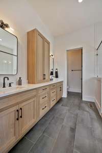 The custom cabinetry in the primary bath features double vanities and ample storage.