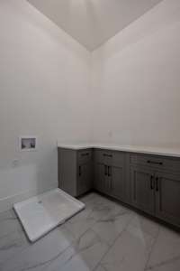 The downstairs laundry room is centrally located to serve the two primary bedrooms.