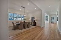 Another look at the light filled dining room. The center hall runs the full length of the home.  The living room is just ahead on the left, and the kitchen is on the right.