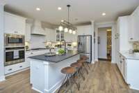 Gorgeous open Kitchen with loads of cabinets and large Island. Kitchen is open to Casual Dining Space and Great Room. Photo is of a similar floor plan, not actual home.