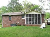 Back of home with screened patio. Great for morning coffee.